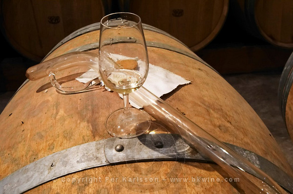Domaine Le Nouveau Monde. Terrasses de Beziers. Languedoc. Barrel cellar. Drawing a sample with a pipette. ISO standard shape wine tasting glass. France. Europe.