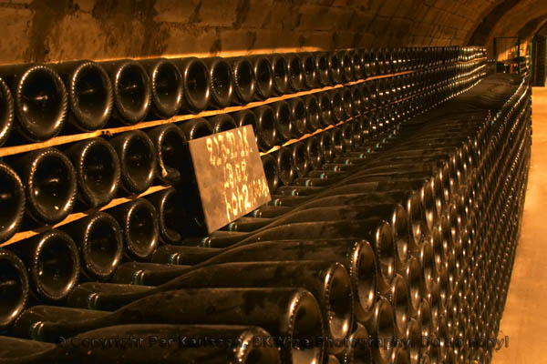 Thousands of bottles stored in a champagne cellar with a chalk board label