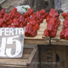 A street market stall selling red bell peppers