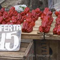A street market stall selling red bell peppers