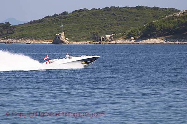 A speed-boat in high speed across the water on the south coast of the Peljesac peninsula. Orebic town. Peljesac peninsula